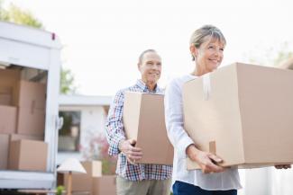 Couple carrying moving boxes