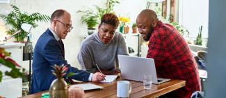 Couple reviewing plan with advisor looking at laptop